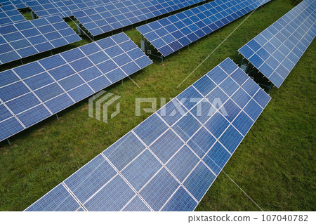 Aerial view of large sustainable electrical power plant with rows of solar photovoltaic panels for producing clean electric energy. Concept of renewable electricity with zero emission 107040782