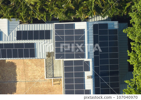 Aerial view of expensive american home roof with blue solar photovoltaic panels for producing clean ecological electric energy. Investing in renewable electricity for retirement income 107040970
