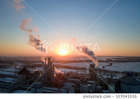 Aerial view of cement factory tower with high concrete plant structure at industrial production area at sunset. Manufacturing and global industry concept Aerial view of cement factory tower with high concrete plant structure at industrial production area at sunset. Manufacturing and global industry concept 107041016