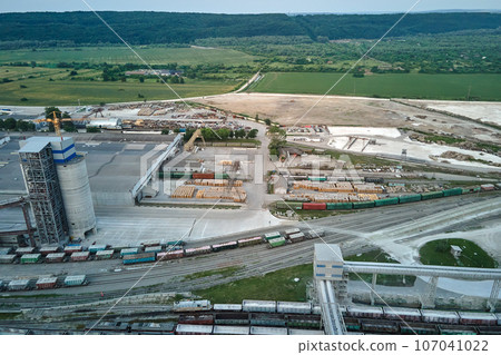 Aerial view of cargo train cars loaded with construction goods at mining factory. Railway transportation of industrial production raw materials Aerial view of cargo train cars loaded with construction goods at mining factory. Railway transportation of industrial production raw materials 107041022