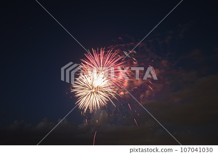 Aerial view of bright fireworks exploding with colorful lights against dark night sky on US Independence day holiday Aerial view of bright fireworks exploding with colorful lights against dark night sky on US Independence day holiday 107041030