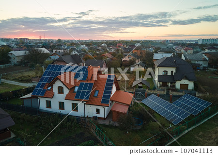Aerial view building roof with rows of blue solar photovoltaic panels for producing clean ecological electric energy. Renewable electricity with zero emission concept Aerial view building roof with rows of blue solar photovoltaic panels for producing clean ecological electric energy. Renewable electricity with zero emission concept 107041113