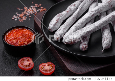 Delicious Spanish smoked sausage fuet with salt and spices 107041177