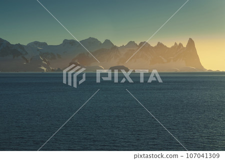 Lemaire strait coastal landscape, mountains and icebergs, Antarctic Peninsula, Antartica. 107041309
