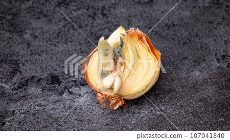 Close-up of half an onion with mold on the table. Spoiled onion. Close-up of half an onion with mold on the table. Spoiled onion. 107041840