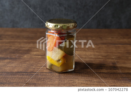 木桌上的罐子裡的各種醃菜 木桌上的罐子裡的各種醃菜 107042278