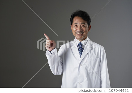 指向左邊的中年醫生，黑色背景 107044431