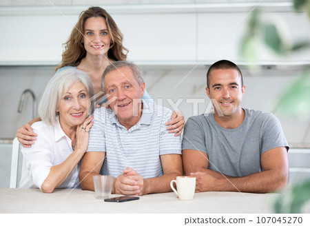 Family of four sitting in kitchen 107045270