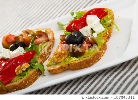 Sandwiches with guacamole, tomatoes, pepper and feta cheese Sandwiches with guacamole, tomatoes, pepper and feta cheese 107045311