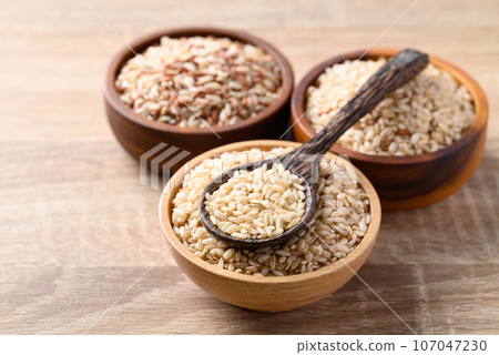 Thai brown rice seed in wooden bowl with spoon, Organic rice, Healthy food ingredient Thai brown rice seed in wooden bowl with spoon, Organic rice, Healthy food ingredient 107047230