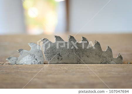 sharp metal saw on wood plank texture background, construction machine 107047694