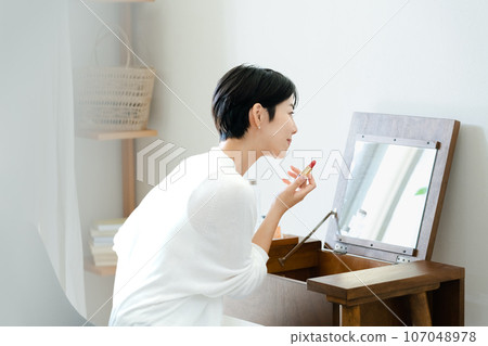 woman applying makeup in the room 107048978