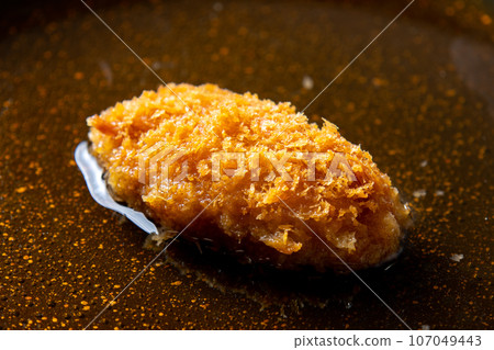 重新製作剩餘油炸食品(炸牡蠣)的烹飪場景。將雞蛋放入裝有高湯的煎鍋中煮沸。 重新製作剩餘油炸食品(炸牡蠣)的烹飪場景。將雞蛋放入裝有高湯的煎鍋中煮沸。 107049443