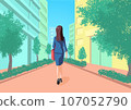 Rear view of a woman wearing a suit walking down a straight street in a built-up area. 107052790