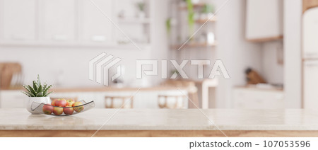 Mockup space on a luxury white marble tabletop with a blurred modern minimal white kitchen Mockup space on a luxury white marble tabletop with a blurred modern minimal white kitchen 107053596