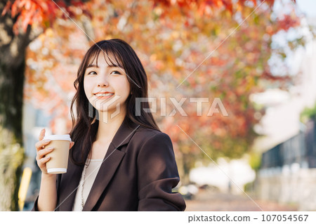 一個女人在喝咖啡，背景是秋葉 107054567