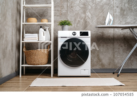 Washing machine in a gray modern laundry room 107054585