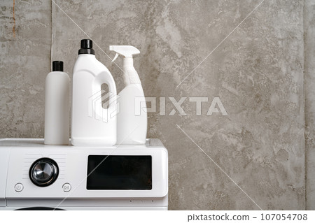 Washing liquid detergents on washing machine in a laundry room 107054708