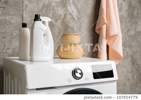 Washing liquid detergents on washing machine in a laundry room 107054779