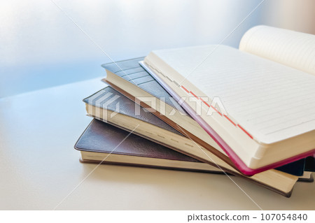 Old diaries and unwritten pages stacked on the windowsill 107054840