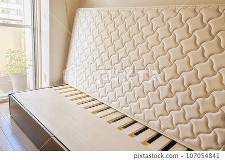 A mattress propped up to allow air to pass through and prevent moisture from accumulating. 107054841