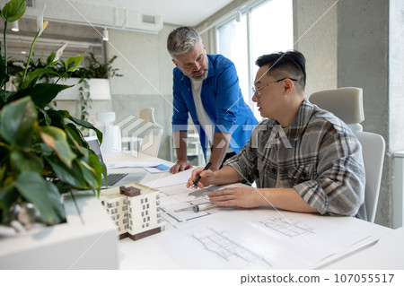 Men working with 3D printer and blueprint for designing mechanical parts in high tech workshop. Men working with 3D printer and blueprint for designing mechanical parts in high tech workshop. 107055517