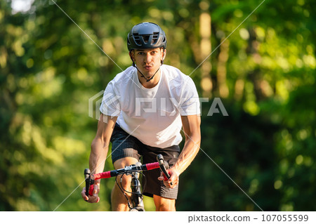 Young male cyclist riding a bike in the forest 107055599