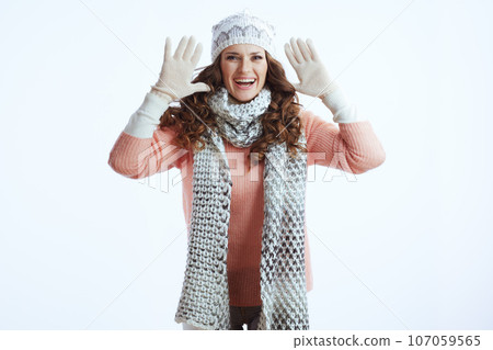 happy modern woman in sweater, mittens, hat and scarf on white 107059565
