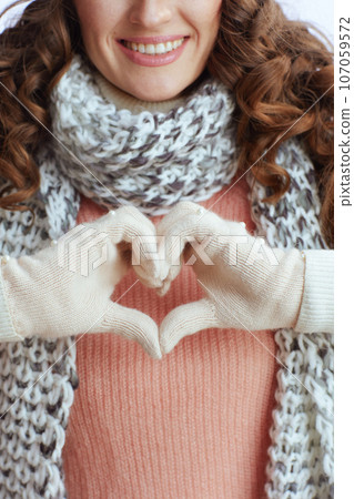 Closeup on trendy woman showing heart shaped hands 107059572