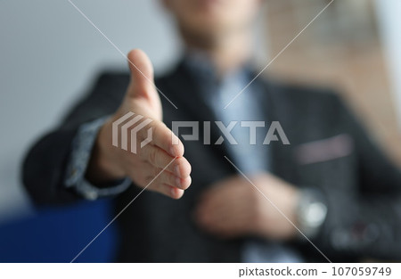 Man in suit stretches out here for handshake 107059749