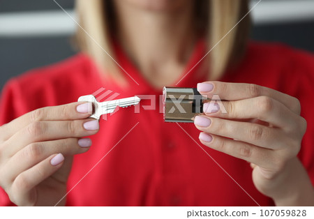 Female hands hold key and lock closeup Female hands hold key and lock closeup 107059828