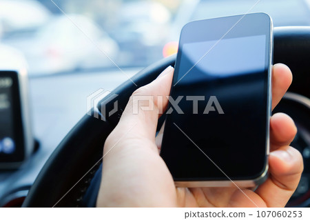 image of using a mobile phone inside of a car 107060253