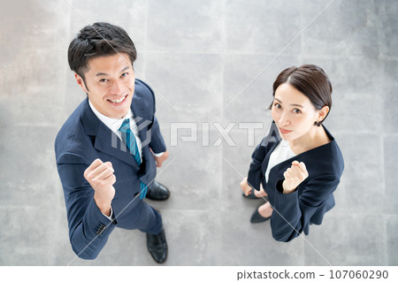 A man and a woman doing a fist pump with a smile A man and a woman doing a fist pump with a smile 107060290