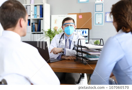 Doctor receives patients in protective medical mask 107060570