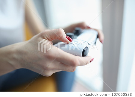 Woman playing computer game with joystick closeup 107060588