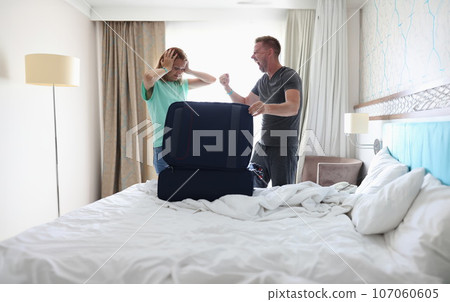 Man and woman are fighting in bedroom near suitcase Man and woman are fighting in bedroom near suitcase 107060605