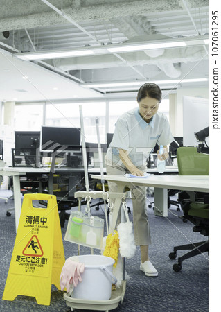 高級女性在辦公室擦拭辦公桌,垂直位置 高級女性在辦公室擦拭辦公桌,垂直位置 107061295