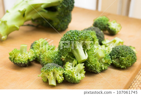 Resh appetizing broccoli inflorescences on wooden board 107061745
