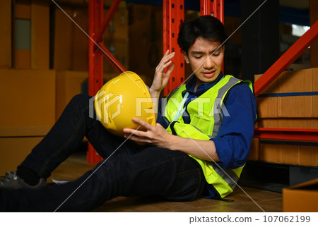 Asian male worker having accident in warehouse during work injured head Safety first and Injury at work Asian male worker having accident in warehouse during work injured head Safety first and Injury at work 107062199