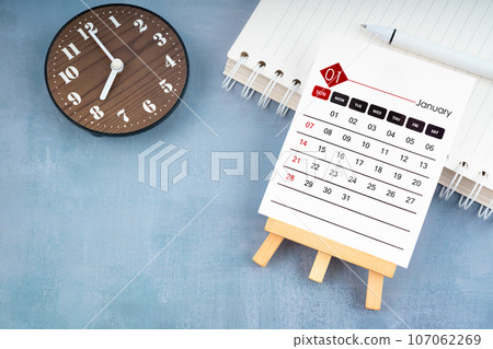 2024 January calendar page and wooden clock. 107062269