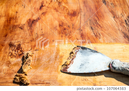 Scraped paint removed with a trowel, renovation of wood surface 107064383