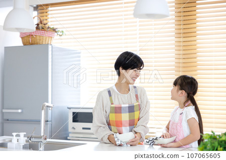 Mother and daughter help kitchen 107065605