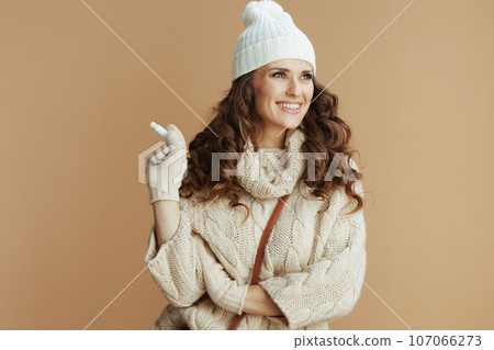 happy elegant woman in beige sweater, mittens and hat happy elegant woman in beige sweater, mittens and hat 107066273