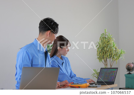 Male and female engineers 1 comparing the fabricated board with the drawings 107066537