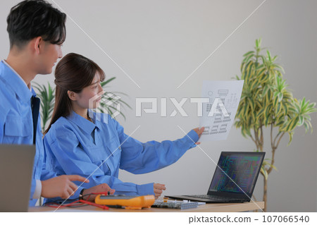 Male and female engineers_Female engineer with drawings 1 Male and female engineers_Female engineer with drawings 1 107066540
