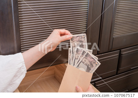 [一位家庭主婦將一張一萬日元的鈔票藏在抽屜裡的信封裡] 107067517