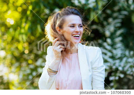 happy modern woman in pink dress and white jacket in city happy modern woman in pink dress and white jacket in city 107068300