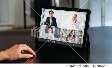 Video telework. Digital office. Diverse men women corporate team tired colleagues discussing business project on tablet screen at modern workplace. Video telework. Digital office. Diverse men women corporate team tired colleagues discussing business project on tablet screen at modern workplace. 107068489