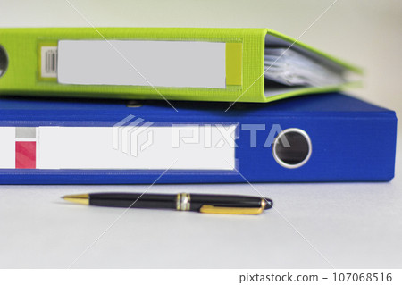 Colorful office folders on white background with pen Colorful office folders on white background with pen 107068516