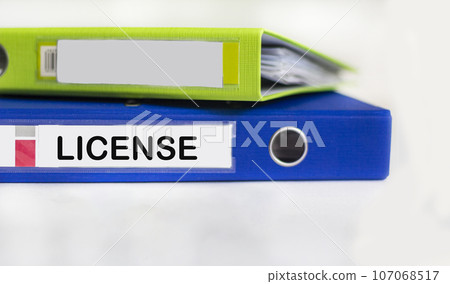 The word License is written on a blue folder and on a white background. the concept of giving  107068517